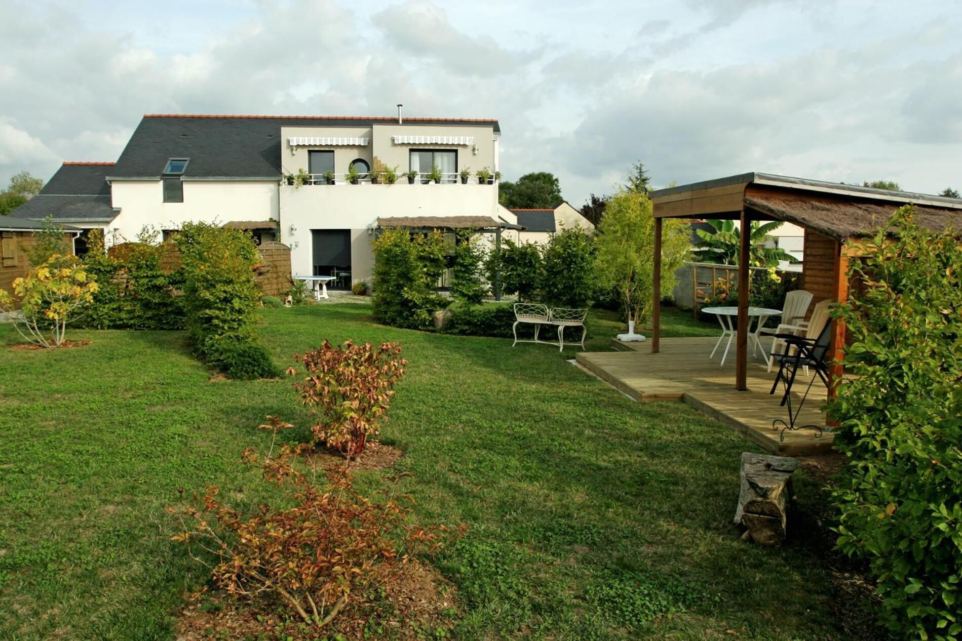 Une maison à deux étages dotée d’un patio couvert.