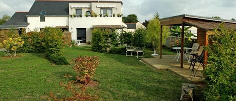 Une maison à deux étages dotée d’un patio couvert.