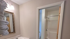 A bathroom with a sink, mirror, and shower area. - Edenbrook Motel (Bar Harbor)