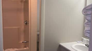 A bathroom with a shower, toilet, and sink.