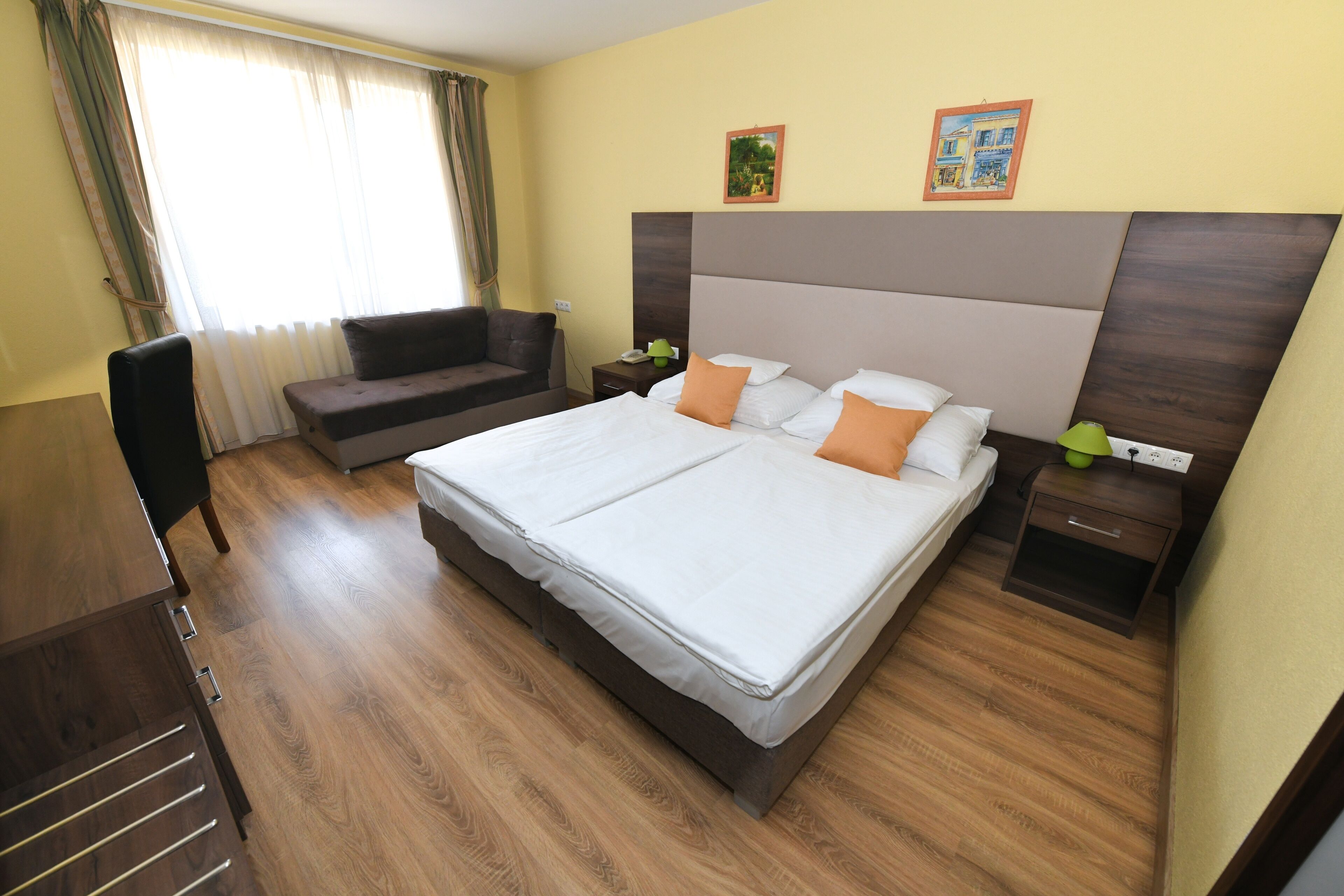 Habitación de hotel con una cama grande, un sofá, un escritorio y una silla.