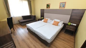 Habitación de hotel con una cama grande, un sofá, un escritorio y una silla.