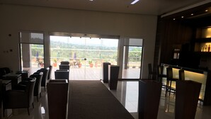 Un moderno vestíbulo de hotel con un pasillo central alfombrado, zonas de estar y vistas al exterior.
