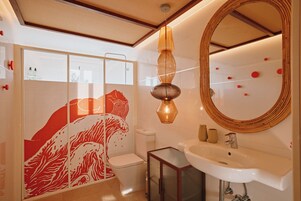 A modern bathroom with a glass shower enclosure, a toilet, a sink, and a mirror.