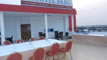 A hotel with a covered outdoor dining area, a bar, and a restaurant.