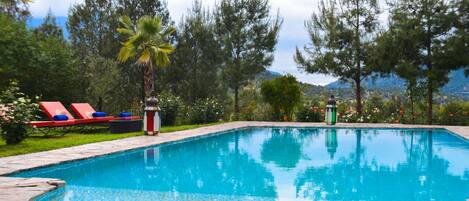 A swimming pool with lounge chairs and a lamp post.