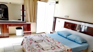 Une chambre d’hôtel avec un lit, un bureau et une chaise.