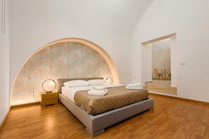 A modern bedroom with a bed, bedside table, and a view of a dining area. - Arco Gentile (Bitonto)