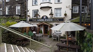 The Ambleside Inn with outdoor seating and a stone facade.