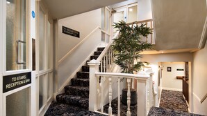 A carpeted staircase with a sign indicating the direction to the second floor room and reception. - The Ambleside Inn - The Inn Collection Group (Ambleside)