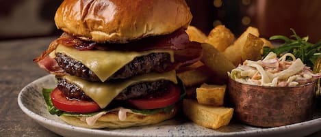 Una hamburguesa con papas fritas y ensalada de col en un plato.