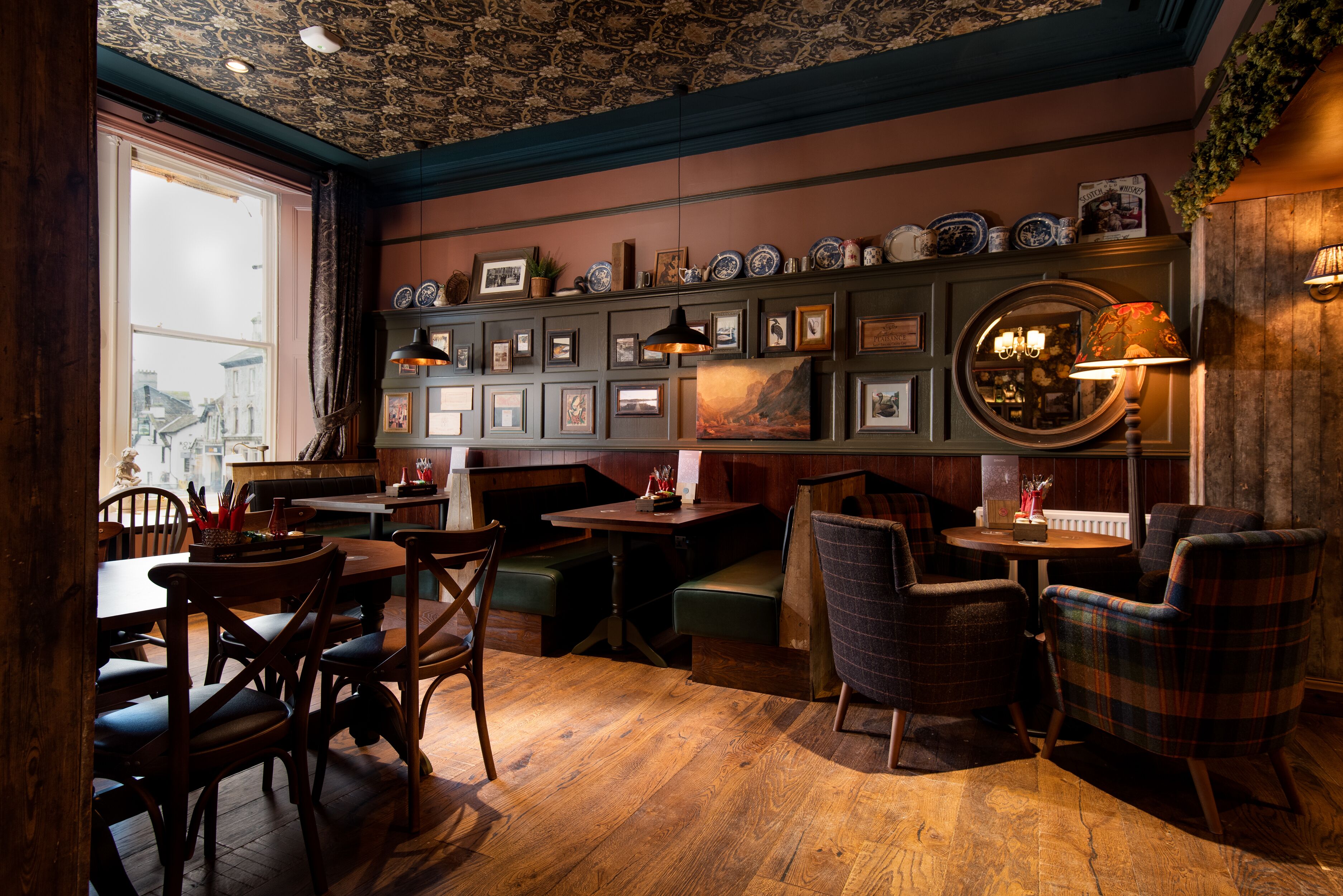 A cozy restaurant with wooden furniture, a patterned ceiling, and wall-mounted decorations.