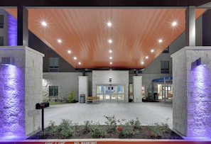 A modern building entrance with a sloped roof, a fire lane, and a gated entrance. - Holiday Inn Express & Suites Plano - The Colony by IHG (The Colony)