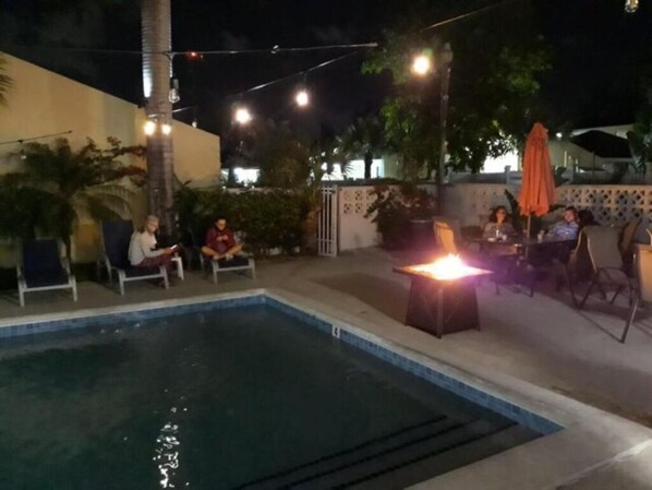 An outdoor pool area with lounge chairs and a fire feature. - Studio B - Queen Room (Chippingham)