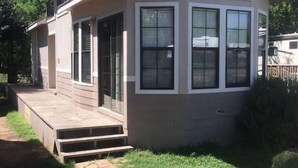 A single-story house with a front porch, large windows, and a covered deck area.
