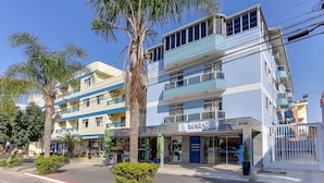 A multi-story hotel with a blue and white facade, a visible restaurant, and a palm tree in the foreground. - Marazul Apart Hotel (Florianópolis)