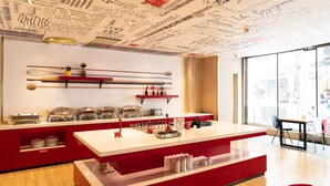 A modern kitchen with a red countertop, stainless steel appliances, and a ceiling with various writings and drawings.
