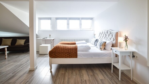 A bedroom with a bed, bedside table, and a window. - Habitat Esslingen (Esslingen)