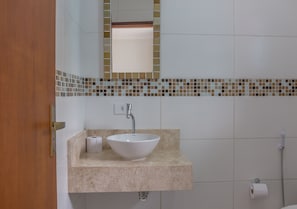 A bathroom with a white sink, a mirror, and a toilet paper holder. - Rentes House Ubatuba (Ubatuba)