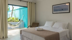 Une chambre d’hôtel avec un lit, un hamac et une vue sur l’extérieur.
