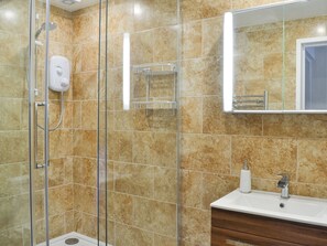 A bathroom with a shower, a sink, and a mirror.