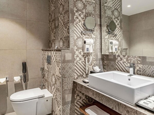 Un baño con inodoro, lavabo y espejo.