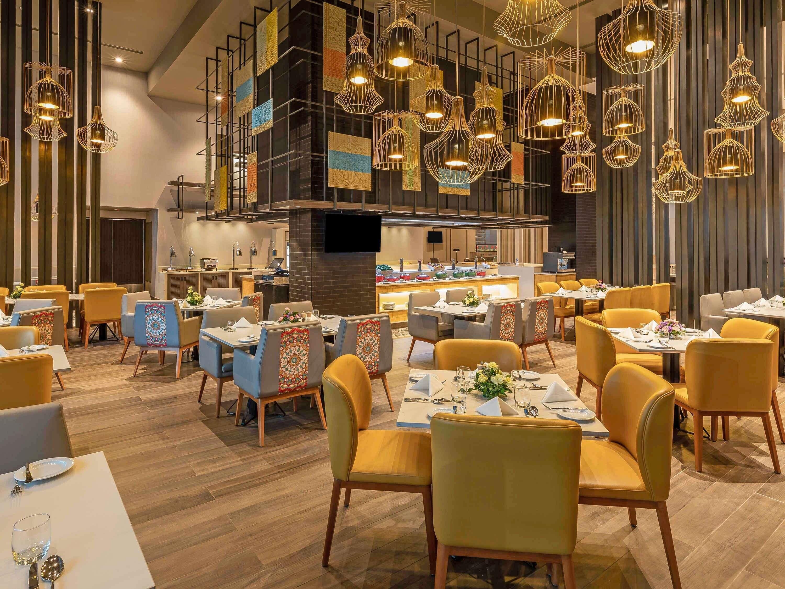 Een modern restaurantinterieur met meerdere eettafels, stoelen en hangende吊灯