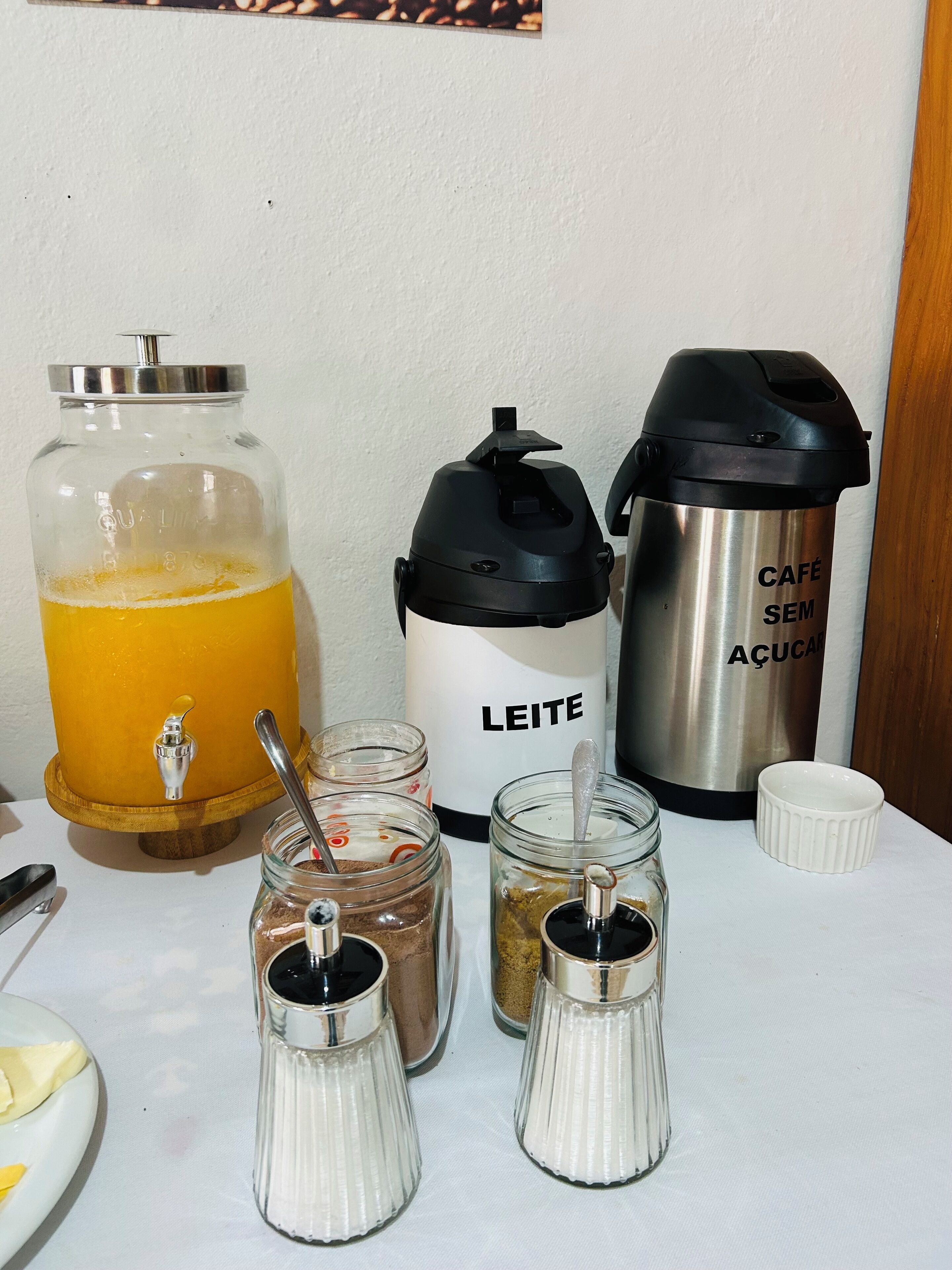 A kitchen counter with a coffee maker, a thermos, and various condiments.