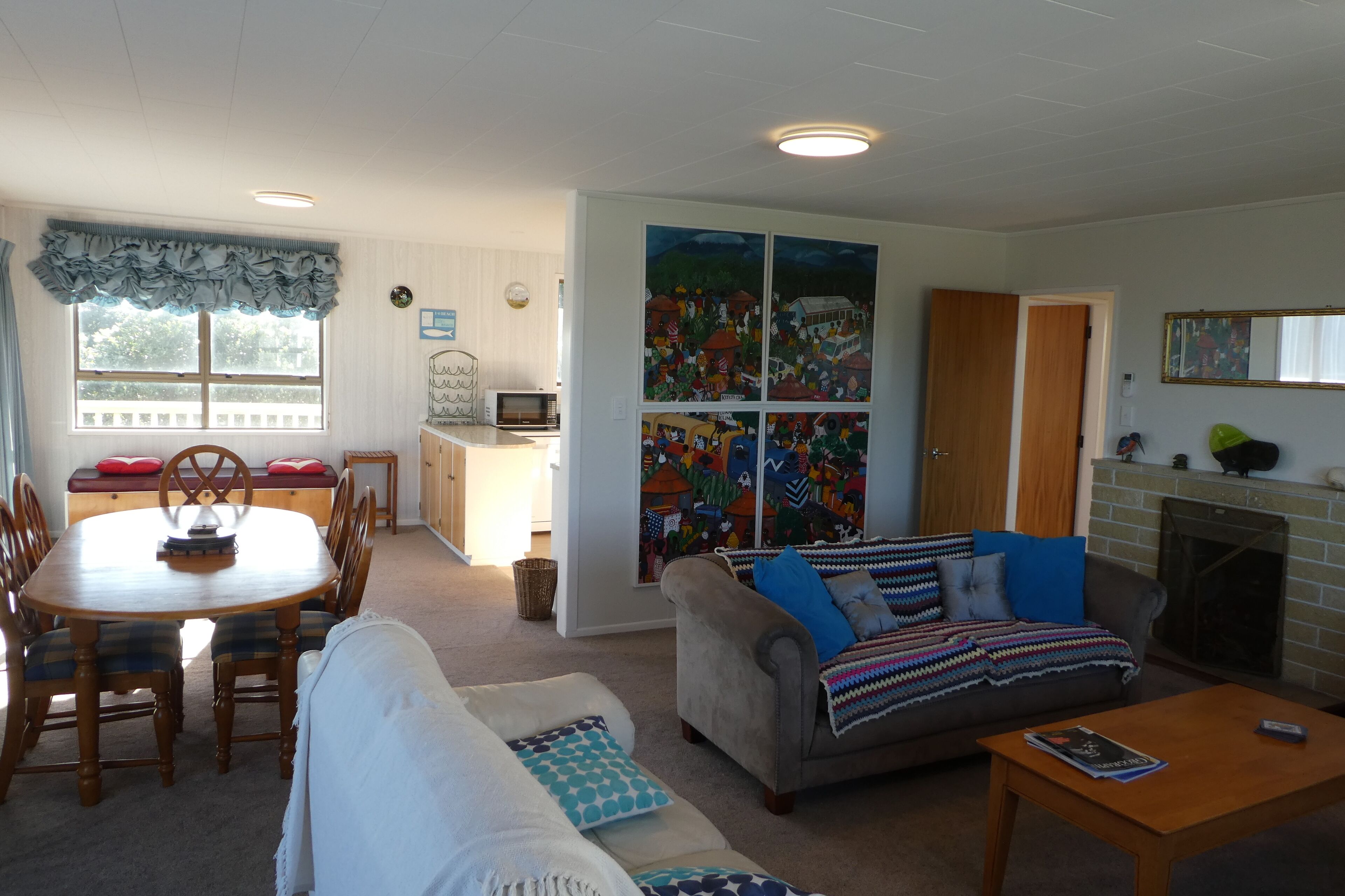 Een woonkamer met een eettafel, bank en open haard.
