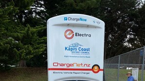 Um carregador rápido para veículos elétricos com sinalização para ChargeNow, Electra, Kapiti Coast District Council e ChargeNet.nz.