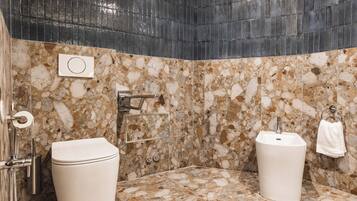 Une salle de bain avec un sol en marbre, des toilettes, un lavabo et un espace douche.