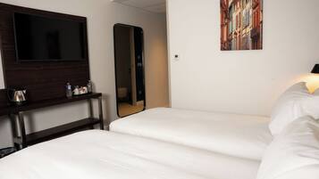 A hotel room with a bed, a TV, a mirror, and a painting on the wall.