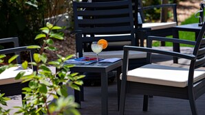 Una terraza con mobiliario exterior, incluyendo sillas y una mesa.