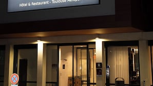 Señal de hotel con el nombre "OSKO" y la inscripción "Hôtel & Restaurant - Toulouse Aéroport", indicando su ubicación en el Aeropuerto de Toulouse.