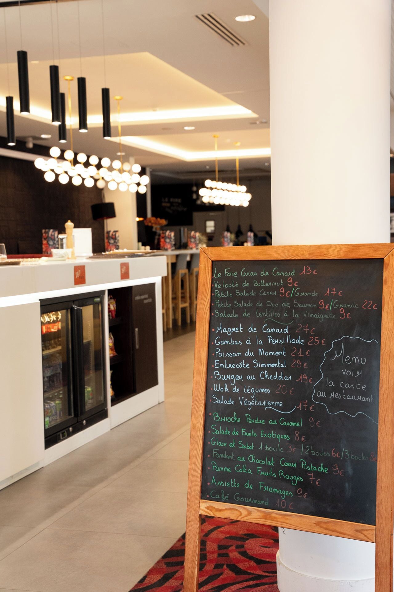 A restaurant interior with a chalkboard menu listing various dishes and prices.