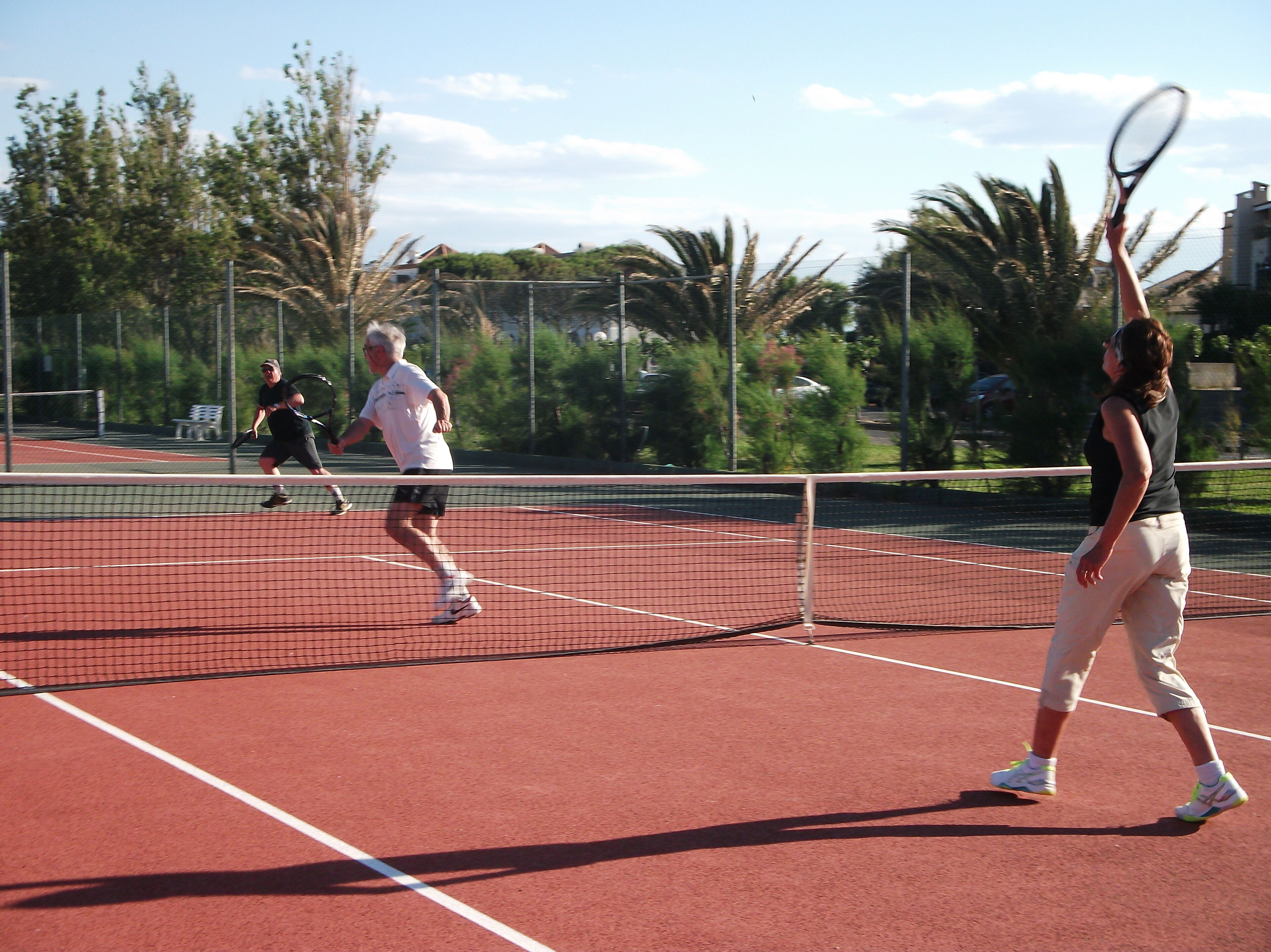 A tennis court with players in motion.