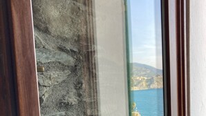 Un muro de piedra con una ventana que ofrece vistas al mar.