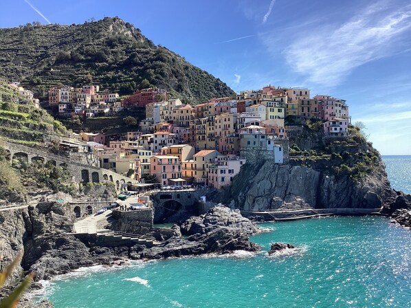A coastal town with colorful buildings perched on a cliff overlooking turquoise waters.