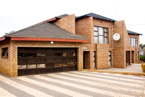 A two-story building with a garage and a satellite dish.