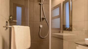 A modern bathroom with a glass-enclosed shower, a white sink, and a mirror.