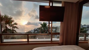 Camera d'albergo con una grande finestra, un letto e una televisione a schermo piatto.