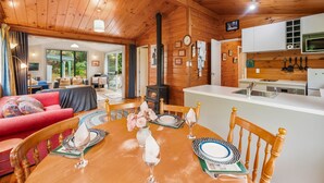 A cozy cabin interior with a dining area, kitchen, and living room. - Little Lockwood - Kuratau Bach (Kuratau)