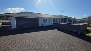 Een modern huis met garage, overdekt terras en een schotelantenne.