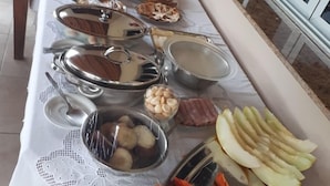 Una mesa de buffet con diversos alimentos y utensilios para servir.