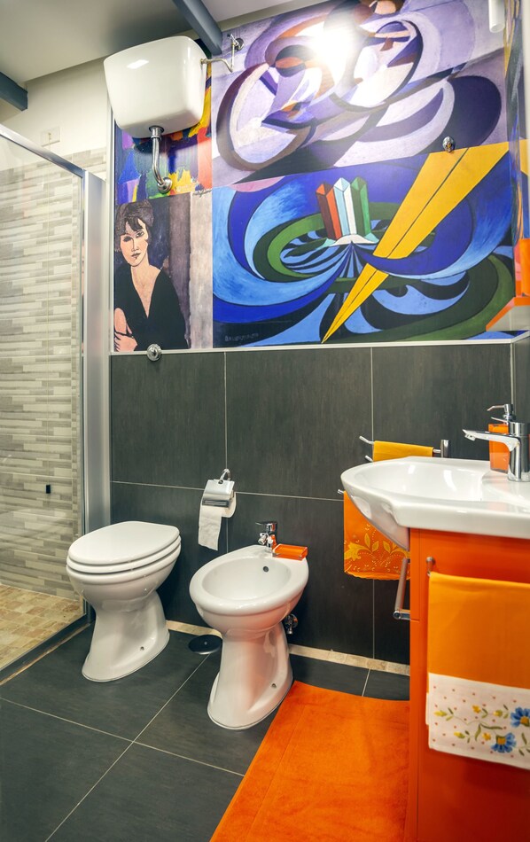 A modern bathroom with a toilet, bidet, and sink.