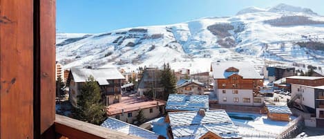 A snowy mountain town with wooden buildings and a clear view of the mountains.