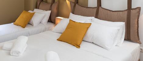 A hotel room with two beds, white bedding, brown headboards, and a wall-mounted air conditioner.