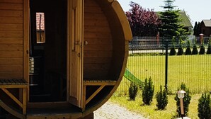 En træhytte med en rund form, en dør og en lille bænk foran.