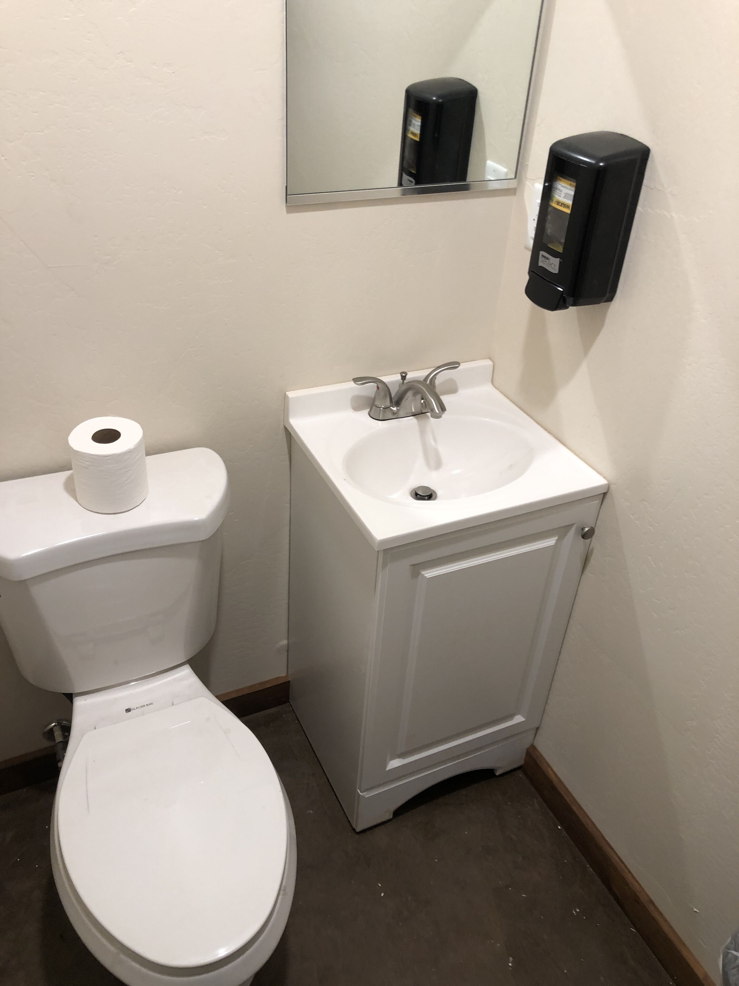 A bathroom with a toilet, a sink, and a hand dryer.