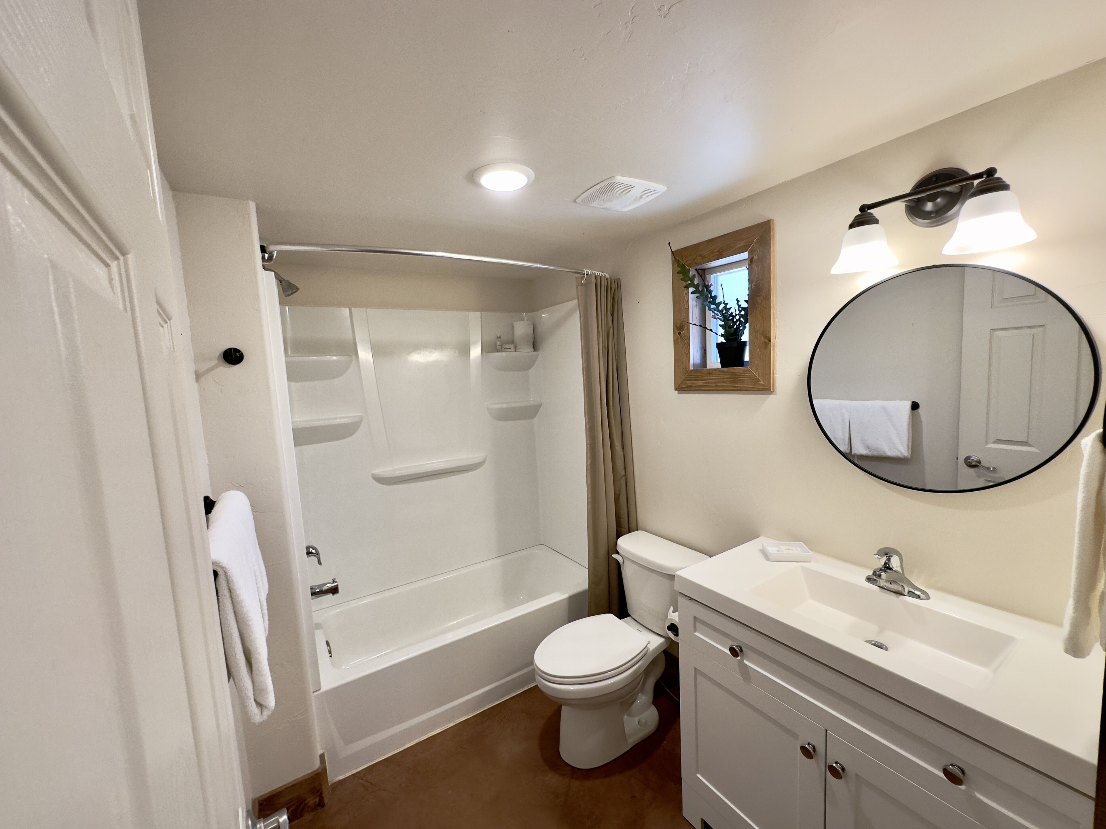 Une salle de bain équipée d’une baignoire, de toilettes, d’un lavabo et d’un miroir.